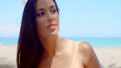 mujer pensativa en la playa mirando en la distancia