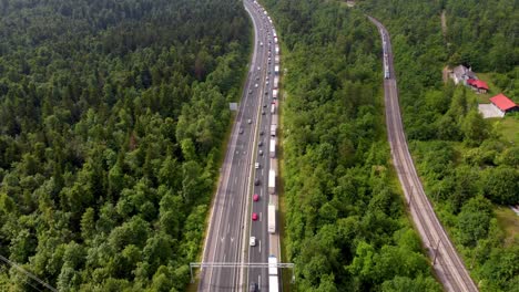 passenger train overtaking cars and trucks on the highway due to heavy traffic on the national road creating congestion and forming two lines of vehicles