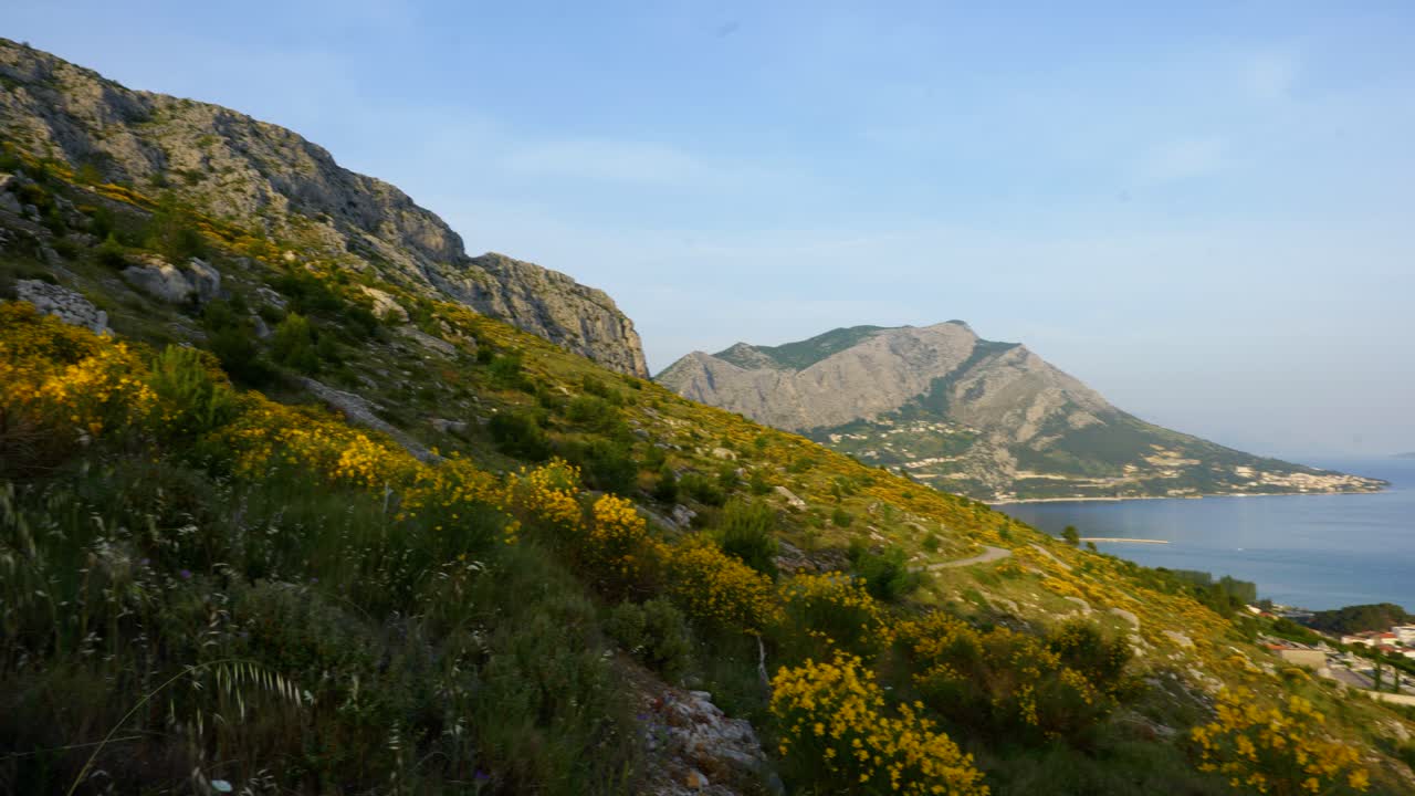 Filmato di viaggio naturalistico cinematografico in 4K di una vista panoramica delle scogliere e delle montagne di Omis vicino a Spalato, Croazia, in una giornata di sole