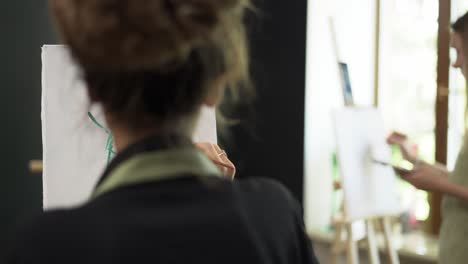 group of students painting female silhouette at art lesson