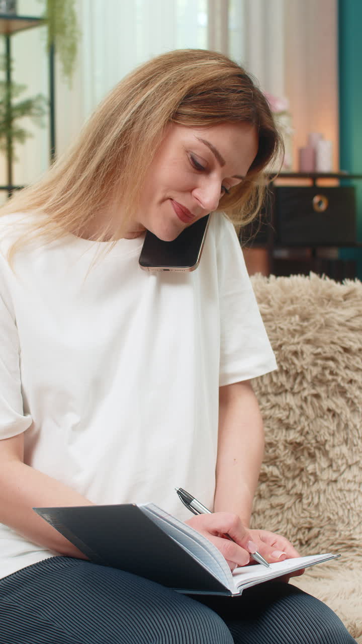 Pregnant woman calls doctor on smartphone listens writes notes in notebook important health advice