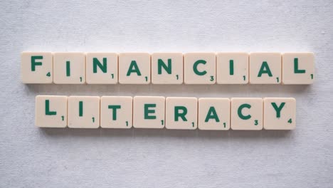 hand forming phrase "financial literacy" with green letters