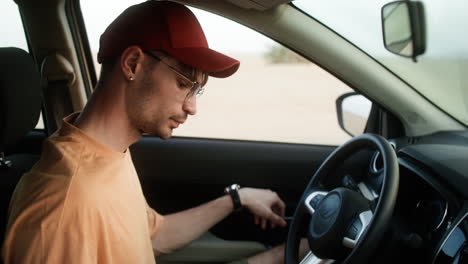 hombre entrando en el coche y conduciéndolo