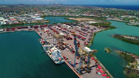 shipping container port docked at cranes, curacao caribbean island, aerial pullback