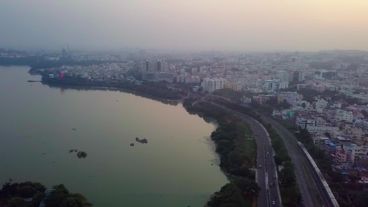 Wide angle aerial shot of Hyderabad cityscape beside a sea in India during evening.
