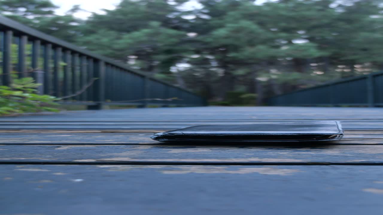 나무로 된 산책로에서 잃어버린 검은 지갑