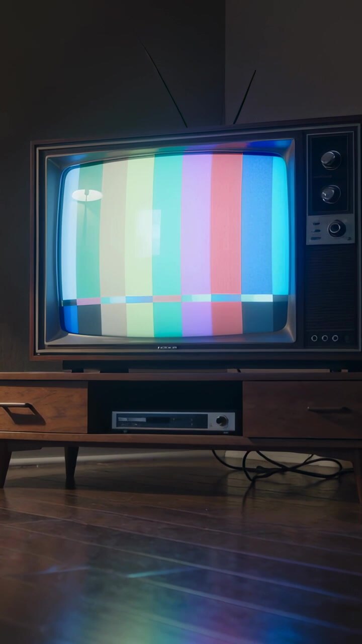 Vertical video: Showing CRT TV flickering color bars after signal loss at home, with VCR and cables
