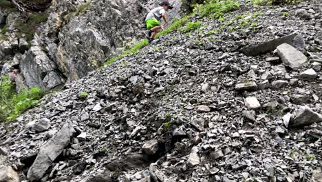 cute young boy doing well while climbing mountain full of rubble