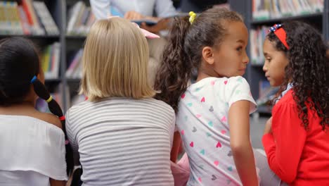 Vista-Trasera-De-Una-Colegiala-Asiática-Mirando-Hacia-Atrás-Y-Sonriendo-En-La-Biblioteca-De-La-Escuela-4k