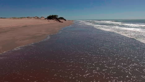 AERIAL---Shore-of-Mar-Chiquita-salt-lake,-Cordoba,-Argentina,-forward-fast-motion