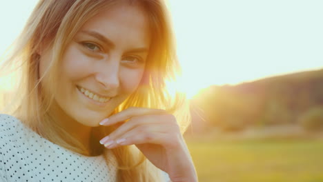 portret van een mooie jonge vrouw bij zonsondergang benadrukt oranje licht haar haar erachter