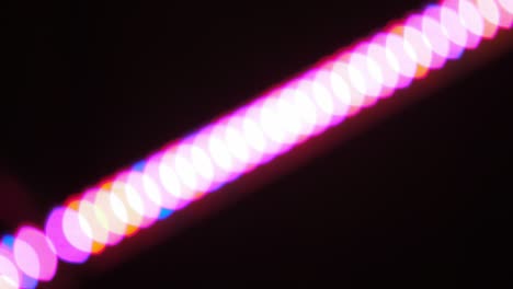 bokeh shot of defocused blurred christmas tree light that is blinking on black