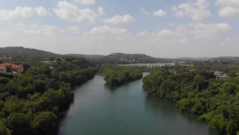 High-drone-shot-of-redbud-isle-with-hill-country-and-neighborhood-clearly-visible