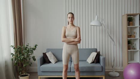 young woman in workout clothes standing in a living room