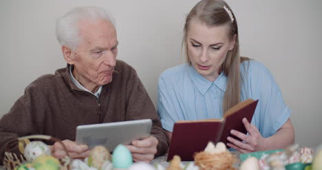 young woman surfing internet with grandfather on digital tablet 5