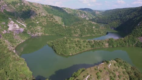 Meandering-Uvac-River-In-Europe-Serbia-With-Two-Boats-on-a-Sunny-Day,-Aerial-Forward-Slow