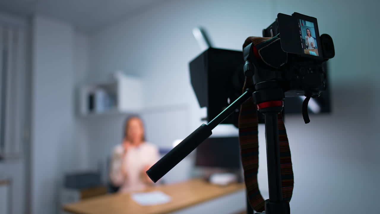 Blog content being recorded in studio. Professional camera taking video of a female speaker. Close up. Blurred backdrop.