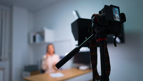blog content being recorded in studio. professional camera taking video of a female speaker. close up. blurred backdrop.