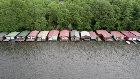 Aerial-view-of-huts-by-the-lakeside-forest-of-Lake-Mirow-in-Germany