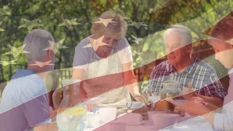 animación de la bandera de los estados unidos sobre amigos caucásicos de alto nivel cenando al aire libre
