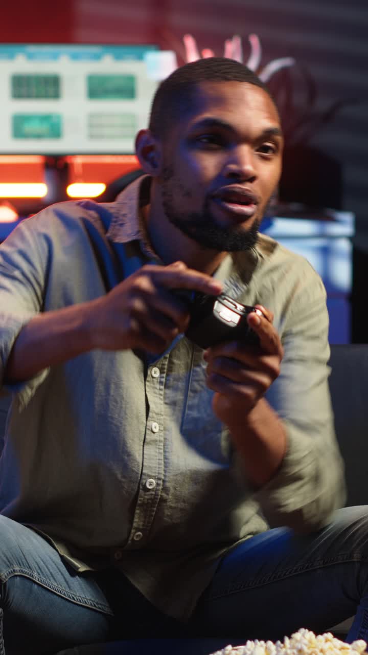 Vertical Video POV young black adult enjoying free time playing shooter games on smart tv