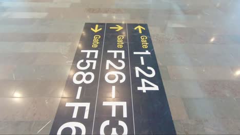 walking over an airport floor sign showing different gates