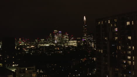 Stürmer-Fliegen-Nachts-über-Stadtviertel.-Freizügiger-Blick-Auf-Die-Leuchtenden-Wolkenkratzer-Der-Innenstadt.-London,-Vereinigtes-Königreich