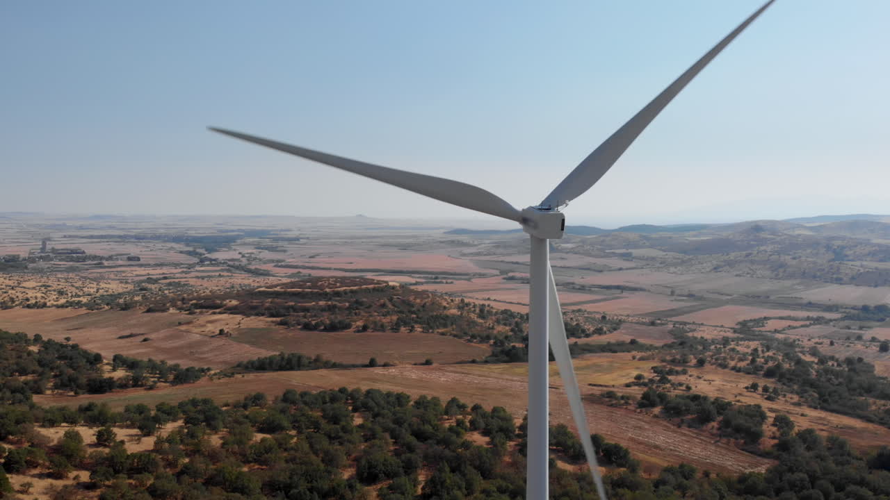 Drone Orbits Wind Turbine Spinning blades Over Dry Summer Fields sunny