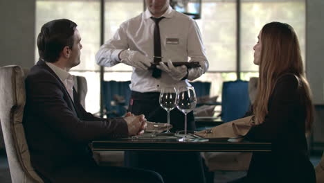 happy couple talking at restaurant. table. business couple reading menu in cafe