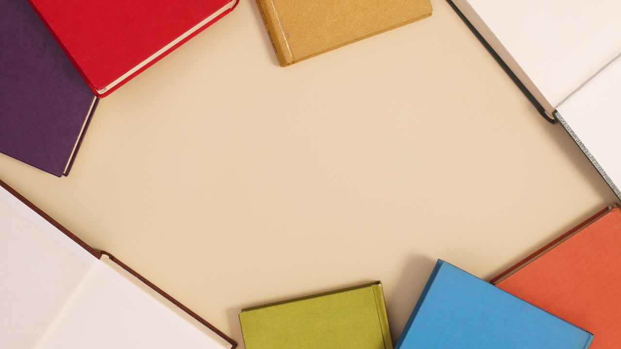 Vintage hardcover books in different colors make frame with copy space and two open. Stop motion flat lay