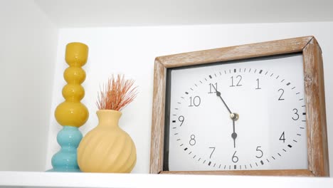 decoración de estantería elegante con reloj y jarrones