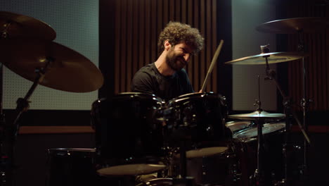 musician playing on drum set in recording studio