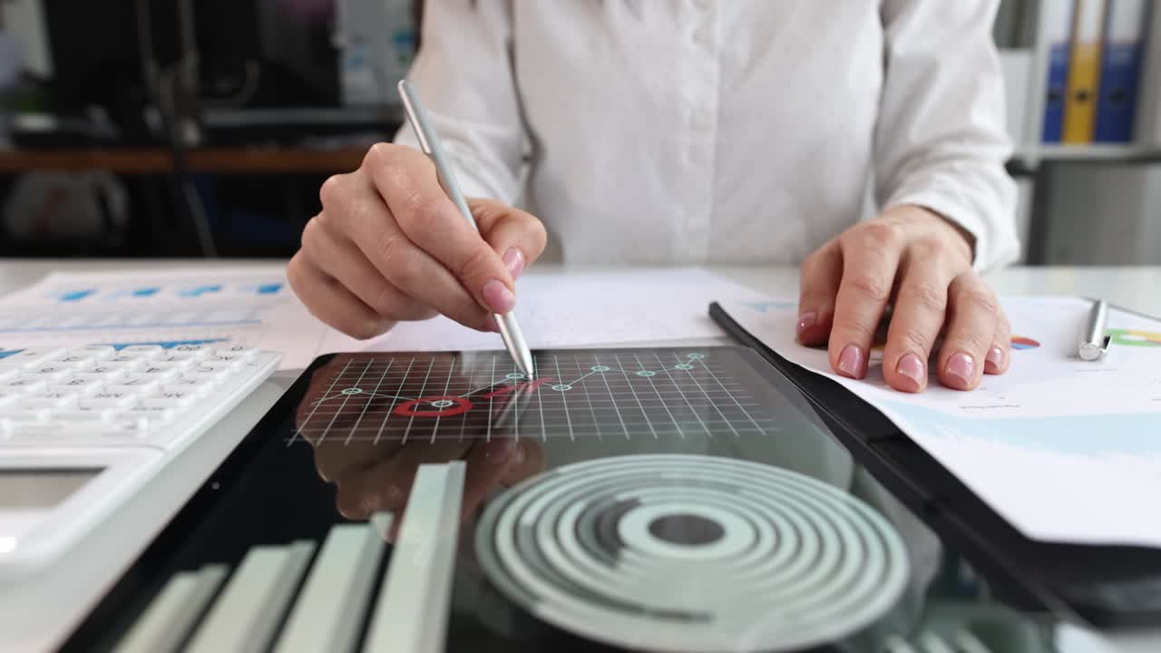 Business consultant puts marks in marketing charts closeup