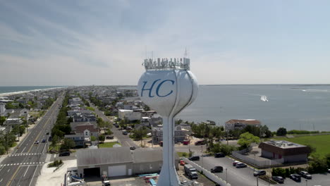 skinny island beach town, with both bayside and ocean visible, water tower with boats in background