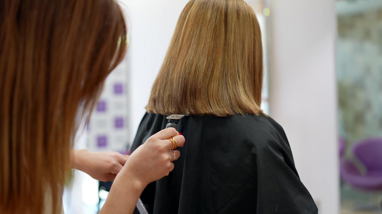Peluquero cortando el cabello de un cliente en un salón