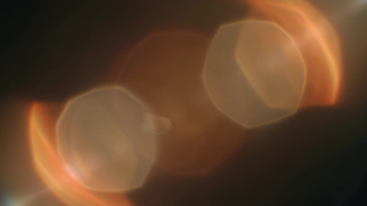 Sovrapposizione astratta di bagliore dell'obiettivo dorato su sfondo nero