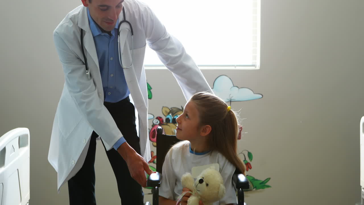 médico masculino interactuando con un niño paciente en la sala