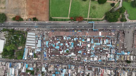 aerial view of a bustling indian city with a densely populated urban area, markets, roads, green spaces, and a river