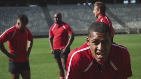 male rugby player standing with hands on hip in stadium 4k