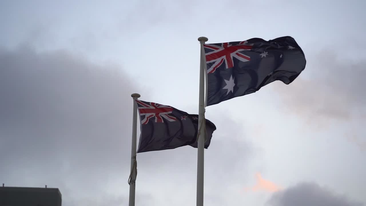 bandera de australia y nueva zelanda ondeando lado a lado contra el cielo, aliados naturales con un fuerte sentido de familia trans-tasman, cámara lenta