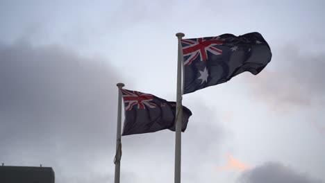 Flag-of-Australia-and-New-Zealand-waving-side-by-side-against-the-sky,-natural-allies-with-a-strong-trans-Tasman-sense-of-family,-slow-motion