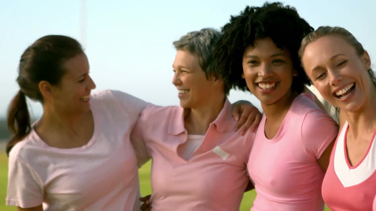 mujeres sonrientes vestidas de rosa para el cáncer de mama
