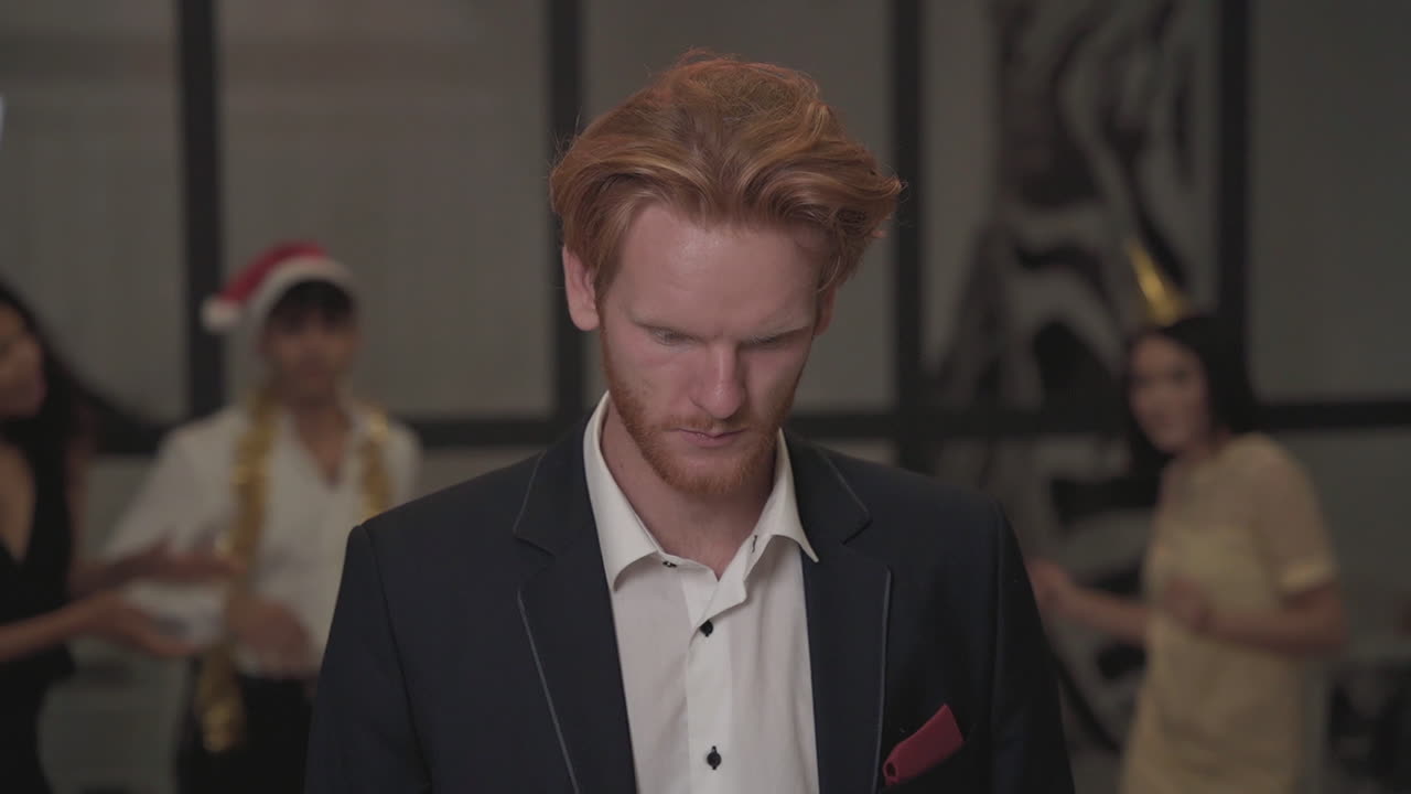 молодой рыжеволосый мужчина смотрит в камеру