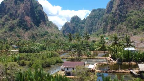 Aerial-of-beautiful-hidden-gem-Rammang-Rammang-Village-with-giant-limestone-cliffs-and-karst-mountains-in-Sulawesi,-Indonesia