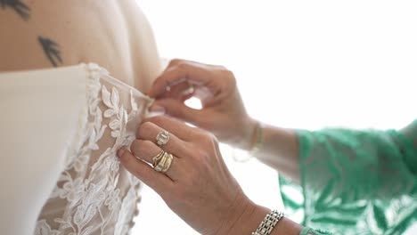 mother of the bride helps her daughter get ready for the wedding