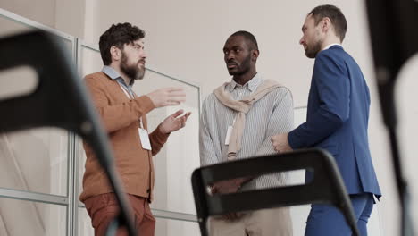 multiethnic men talking in office