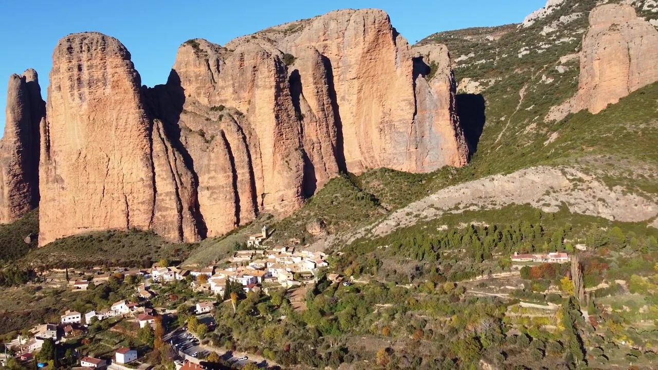 Mallos de Riglos. Huesca, Aragona, Spagna. Montagne imponenti con pareti verticali e un villaggio bianco ai loro piedi. Vista aerea. Famosa area di arrampicata. Sentiero escursionistico Camino del Cielo (Sentiero del Cielo).