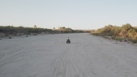 man riding a motorcycle lifting a dust trail behind him