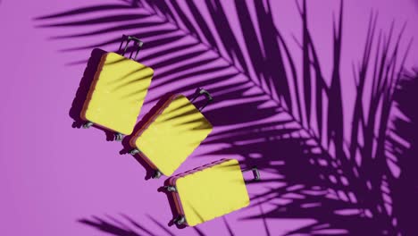 Suitcases-on-tropical-pink-background-vertical