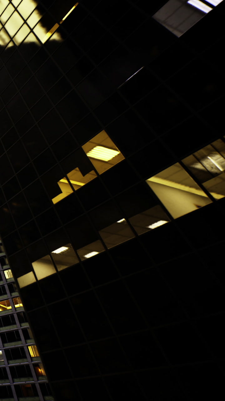 City building with lit windows at night shows urban activity happening